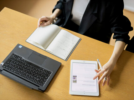 A person works on online course with a laptop, tablet and paper notebook, top view. Photo by Kalle Kataila