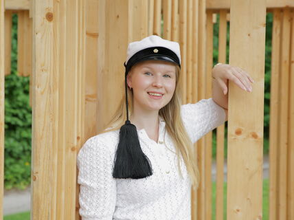 Olivia Matilainen hymyilee kameralle ylioppilaslakki päässä.