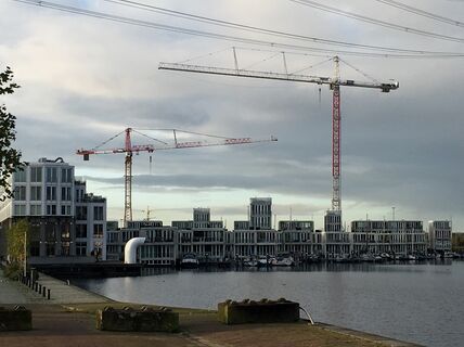 Cranes building houses on the waterfront