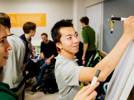 Students brainstorming at a whiteboard