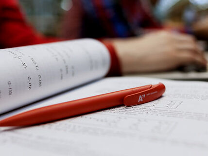 A book opening and a pen in the picture. Picture: Aino Huovio
