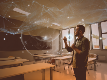 Henkilö seisoo modernissa luokkahuoneessa, vuorovaikuttaen hehkuvien digitaalisten hologrammien kanssa.
