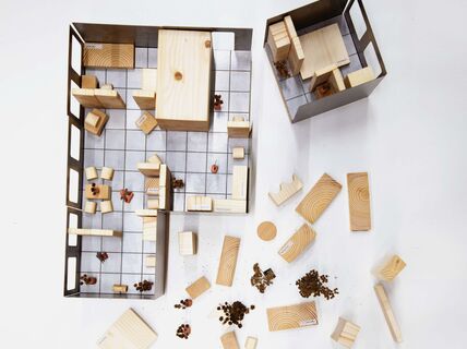 Board game featuring wooden blocks representing furniture and rooms. The picture is from a diploma work by Nhung Pham.