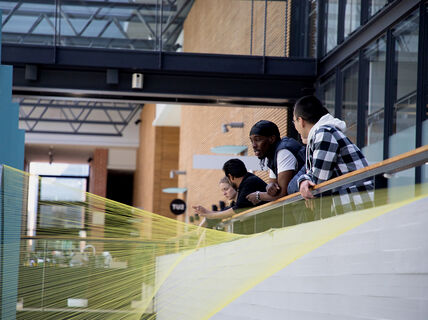 Students leaning on railing.