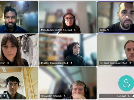 A virtual meeting with eight participants in various settings, plus one blank screen with a user icon.