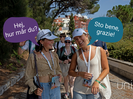 En grupp människor går utomhus, två kvinnor längst fram samtalar. En säger 'Hej, hur mår du?' och den andra svarar 'Sto bene, grazie!'.