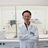 Pingchao Ke in the laboratory with safety gear standing in front of lab equipment smiling