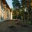 Thumbnail of Side of a modern building with windows next to a pine forest. The ground is bare with a few young plants.