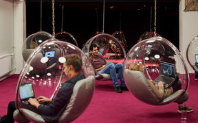 Opiskelijoita työskentelemässä katosta roikkuvissa pallotuoleissa Harald Herlin -oppimiskeluksen Makerspacessa