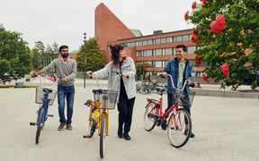 Three people with bikes in front of Väre building