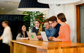 Five people at desk with computers