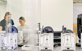 Mies- ja naisopiskelija työskentelemässä laitteen ääressä. 