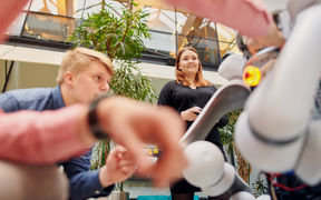 Students of School of Electrical Engineering around a robot.