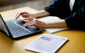 Someone working on a laptop typing.