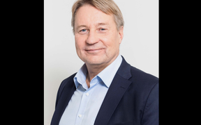 Mobidiagin toimitusjohtaja Tuomas Tenkanen hymyilee kameralle, yllään sininen puku.