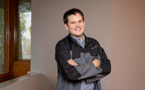 Mies seisoo ja katsoo hymyillen kameraan.