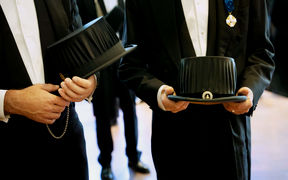 Two persons holding doctor's hats