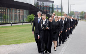 A procession of people dressed in dark clothing