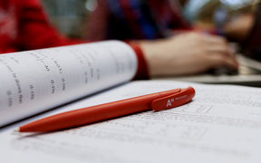 A book opening and a pen in the picture. Picture: Aino Huovio