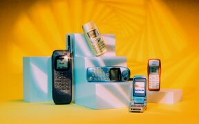 Five vintage Nokia mobile phones on white pedestals with a yellow background and geometric light patterns.