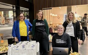 Aalto University Summer School team members at the registration desk. Four women in Aalto University t-shirts.