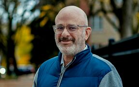 Man is standing on the street, background is blurred
