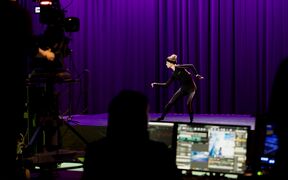 A dancer performing in a motion capture studio setting