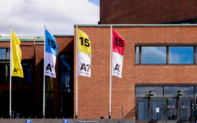 Aalto University 15 years anniversary flags next to a regular Aalto University yellow flag