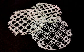 Three white, circular lace patterns on a black background, each with a unique geometric design.