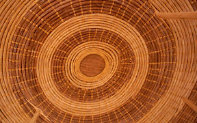 Close-up of a round woven basket in light brown, seen from above with concentric rings
