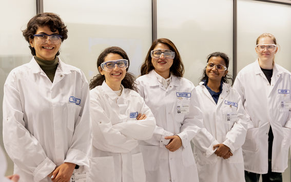 Five students wearing white coats visiting Kemira R&D Center in Espoo.