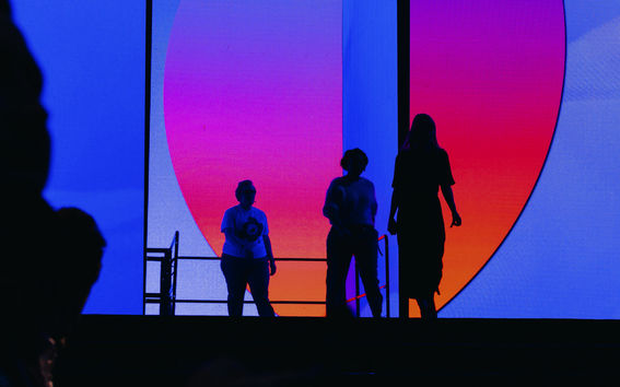 People walking in front of a colorful wall