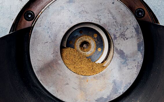 Close-up of a metal grinder with brown powder residue inside.