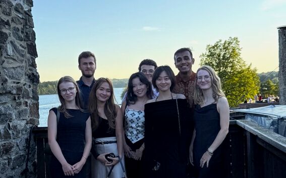 Interns by an old stone wall above the sea.