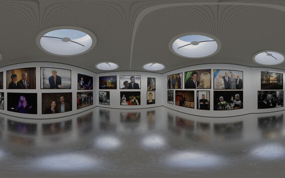 Galleria, jossa on erilaisia muotokuvia ja valokuvia seinillä. Katossa on pyöreitä kattoikkunoita ja lattia on heijastava.