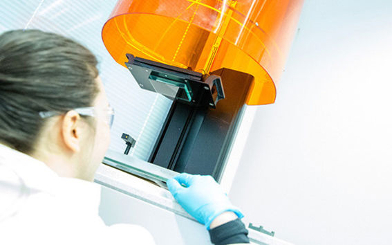Health and Wellness researcher looking at a 3D printer from below