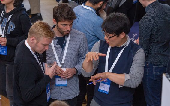 IDBM student explaining a concept to IDBM Impact 2018 event visitors