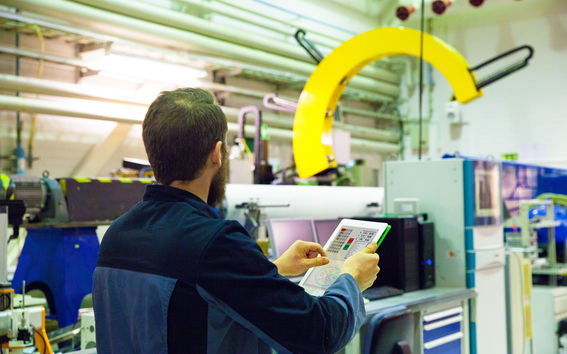 Man operating a paper machine rotor with iPad