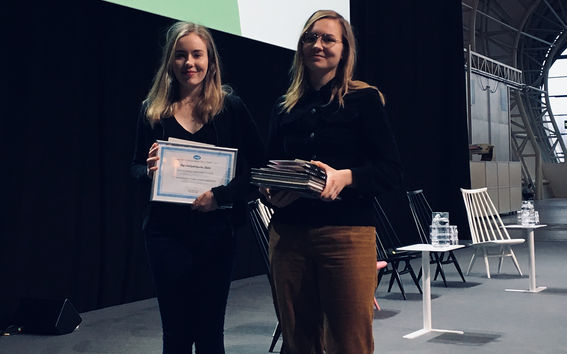 Ella Eskola ja Iina Silventoinen pitelevät käsissään voittoplakaateja ja seisovat matkamessujen maata pitkin -osion lavalla