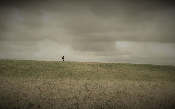 A lone person on a desolate Hamburg field, enjoying the tranquility and calm 