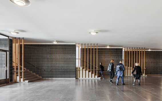 Neljä opiskelijaa kulkemassa Otaniemessä Kandidaattikeskuksen aulassa.