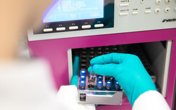 Henkilön käsi asettelemassa laboratoriovälinettä.