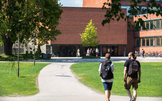 Kaksi henkilöä kävelee Alvarinaukiolla kohti Kandidaattikeskusta.
