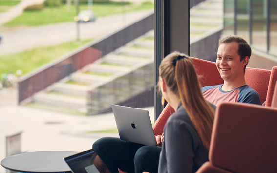Kaksi opiskelijaa istuu ikkunan ääressä.