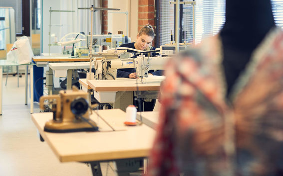 Woman sewing fabric at the School of Arts, Design & Architecture