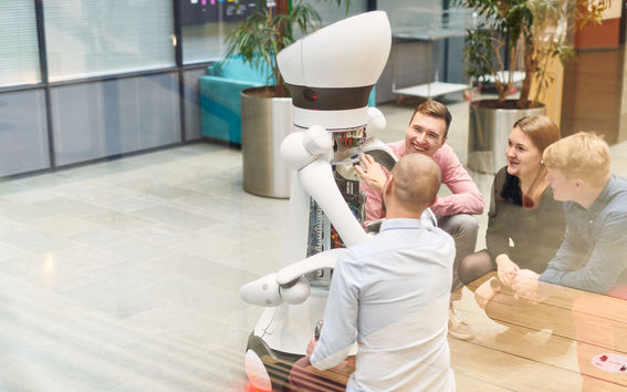 School of Electrical Engineering students discussing around an electrical robot