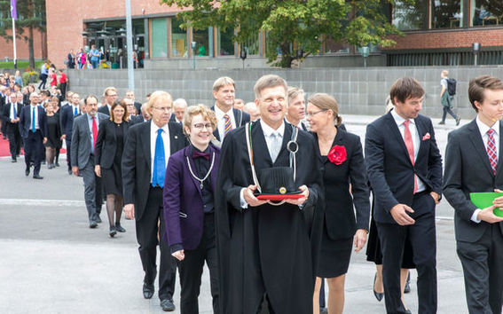 people walk in a procession in front of the building