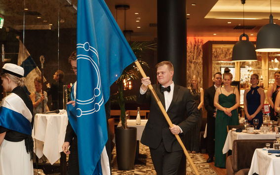 Niko holding the chemistry guild flag at annual party
