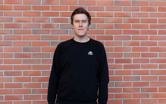 Johan Sarpoma standing in front of brick wall.