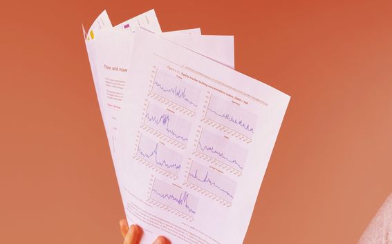 Käsi pitelee asiakirjoja, punainen tausta